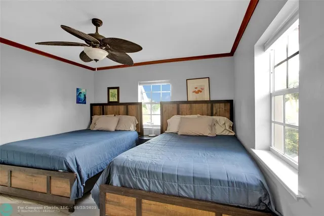 a bedroom with two large bed and a large window