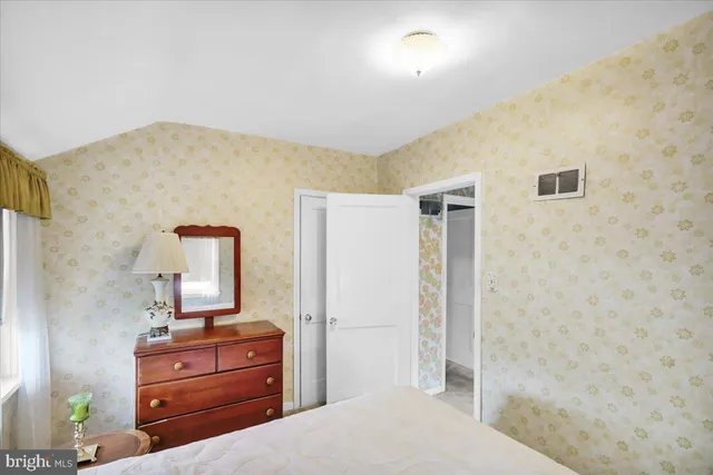 a bedroom with a bed and a dresser in it