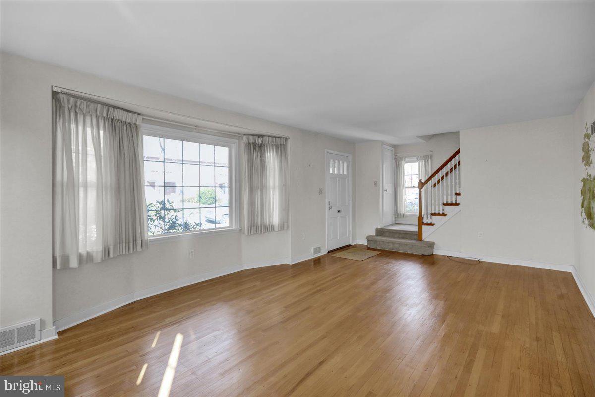 1510 Garfield Avenue Wyomissing, PA 19610 - Photo 4 of 26 an empty room with wooden floor and windows