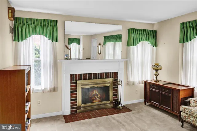 a living room with furniture a mirror and a fireplace