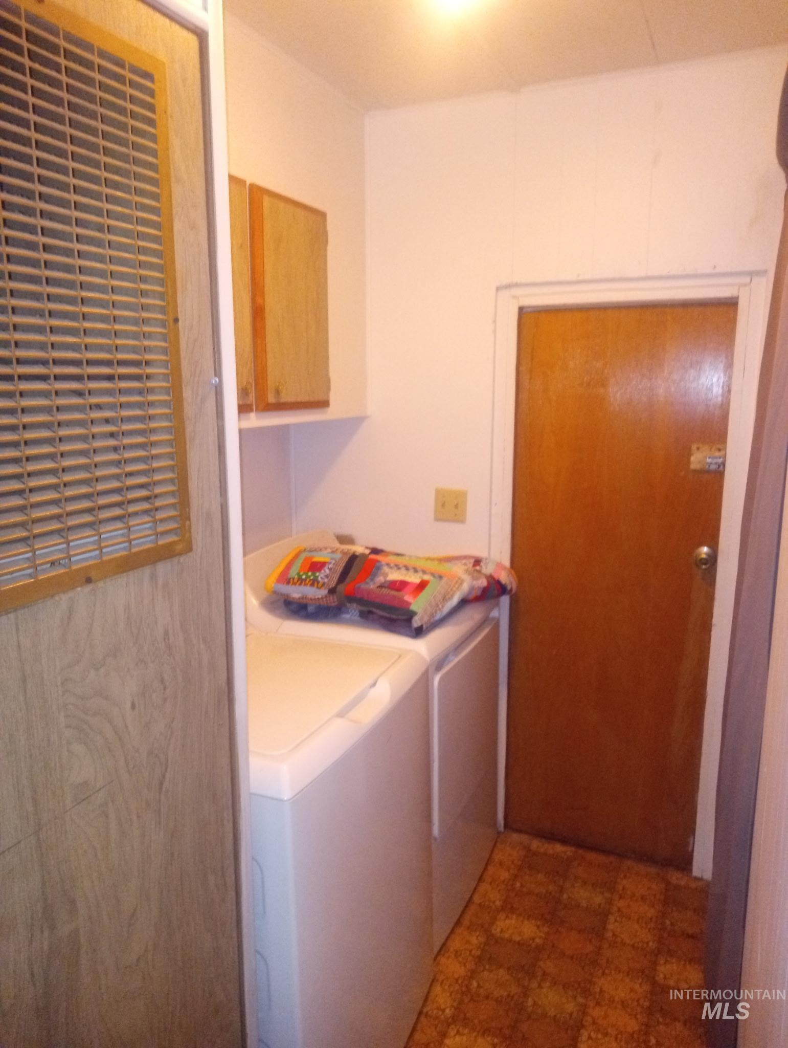 749 Ritter Avenue Vale, OR 97918 - Photo 23 of 28 Washroom featuring dark floors, separate washer and dryer, and cabinet space