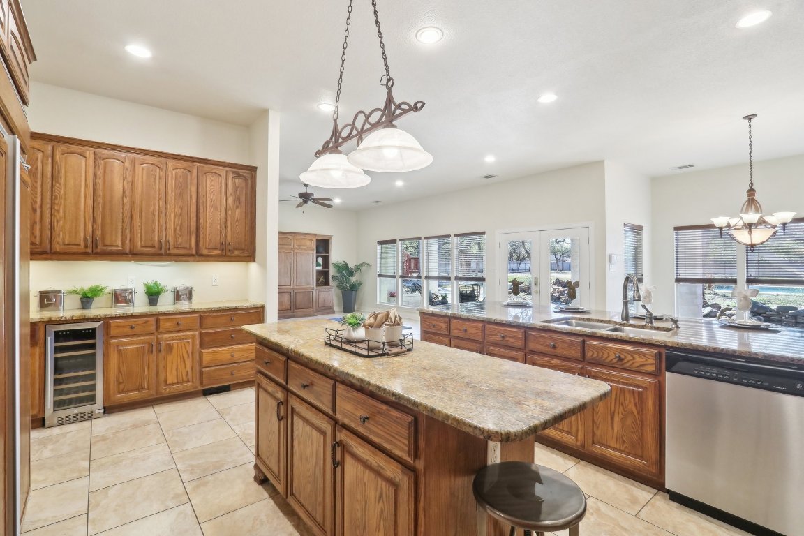 294 Logan Ranch Road Georgetown, TX 78628 - Photo 12 of 39 a kitchen with a stove a sink dishwasher a kitchen island with wooden cabinets and floor