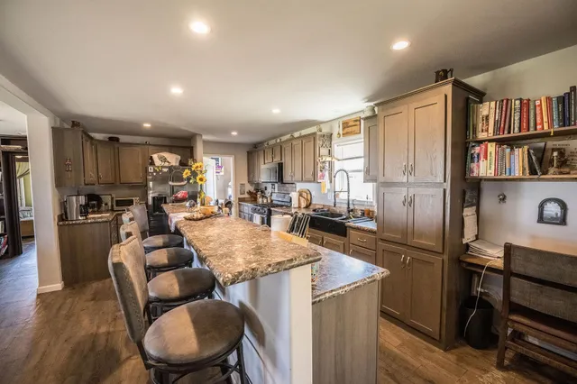 a view of kitchen with refrigerator stove dining table and chairs