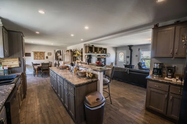 a kitchen with stainless steel appliances granite countertop a stove top oven a sink a counter space and cabinets