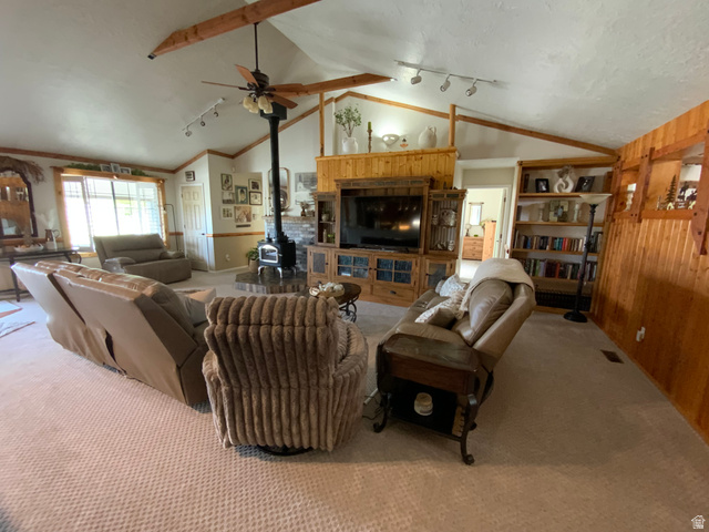 1061 Copper Street Stockton, UT 84071 - Photo 4 of 43 Spacious living area featuring a vaulted ceiling with exposed wood beams, a central wood stove