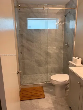 a bathroom with a sink vanity mirror and toilet
