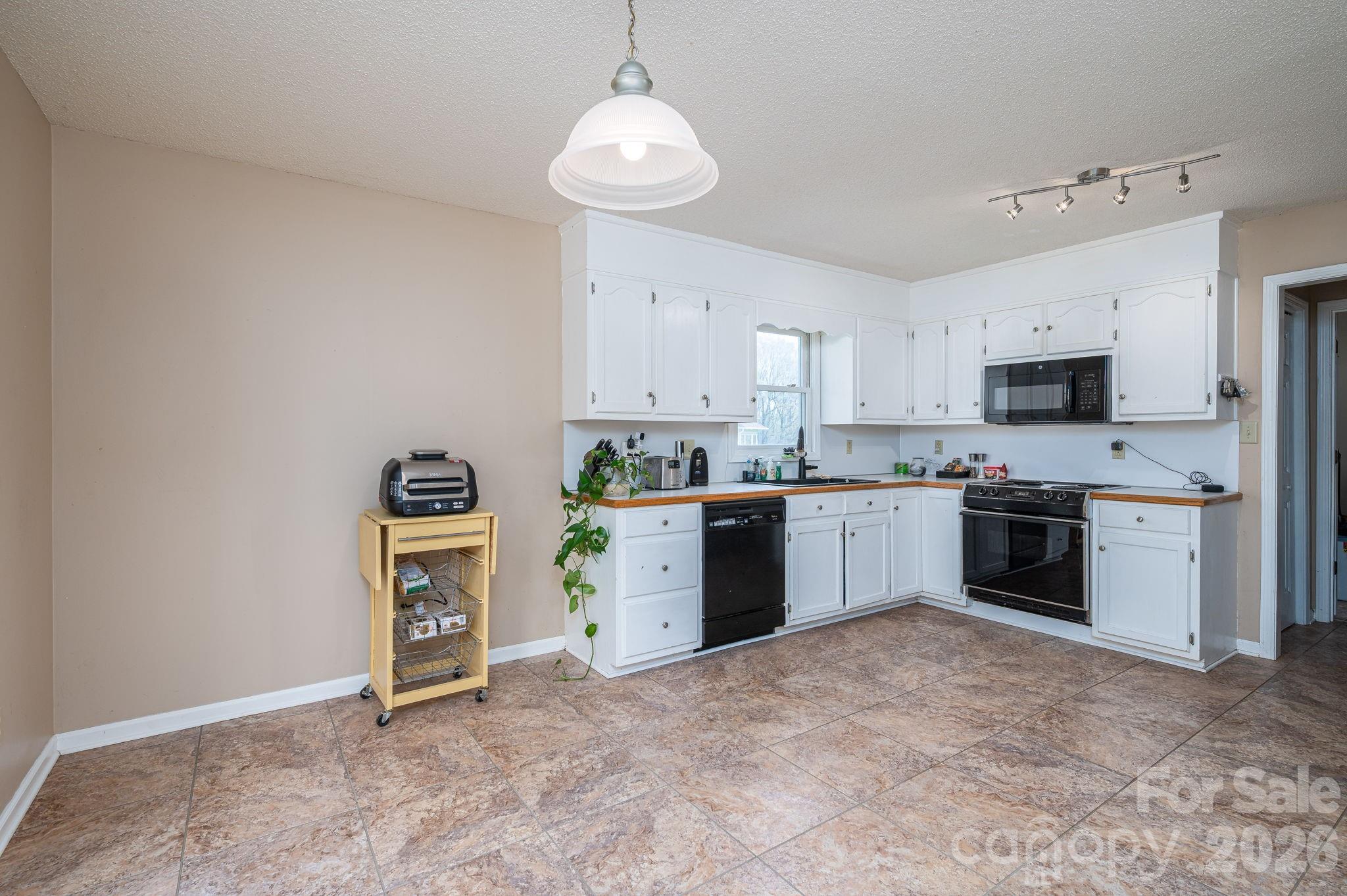 4503 Briar Creek Road Maiden, NC 28650 - Photo 12 of 48 a kitchen with kitchen island granite countertop a stove top oven a sink a counter space and cabinets