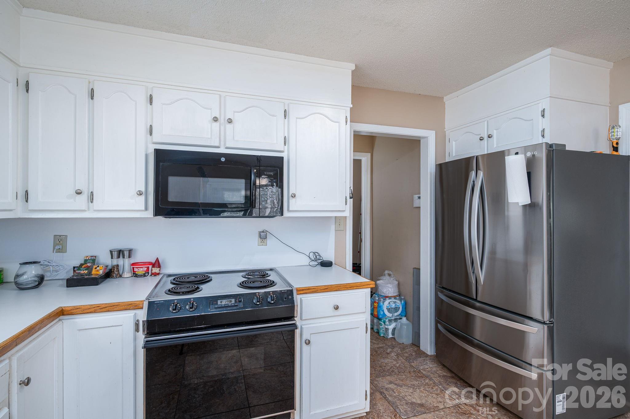4503 Briar Creek Road Maiden, NC 28650 - Photo 16 of 48 a kitchen with stainless steel appliances a refrigerator stove and white cabinets
