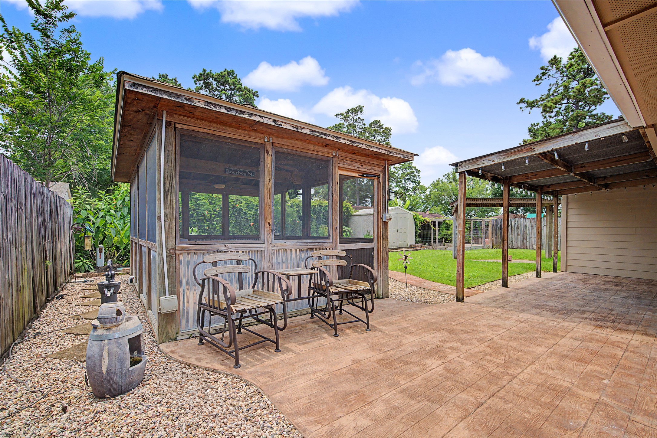 4210 Mossygate Drive Spring, TX 77373 - Photo 27 of 33 Backyard features a covered patio plus a covered screened outdoor living space with sink, prep area, cabinetry, ceiling fans and TV — a great setup for entertaining or relaxing outdoors.