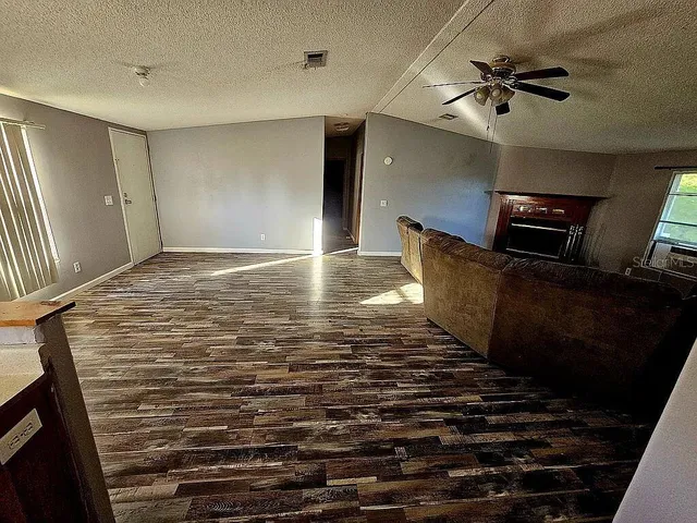 a view of an empty room with a ceiling fan and window
