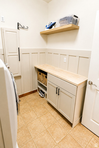 1055 North 1000 East Mapleton, UT 84664 - Photo 36 of 112 Laundry area featuring beige square tile flooring, a custom built-in cabinet with a wood-finish countertop, a floating wood-finish shelf, and board and batten wall detailing
