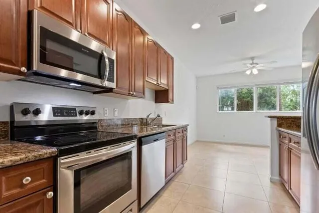 a kitchen with stainless steel appliances granite countertop a stove microwave and sink