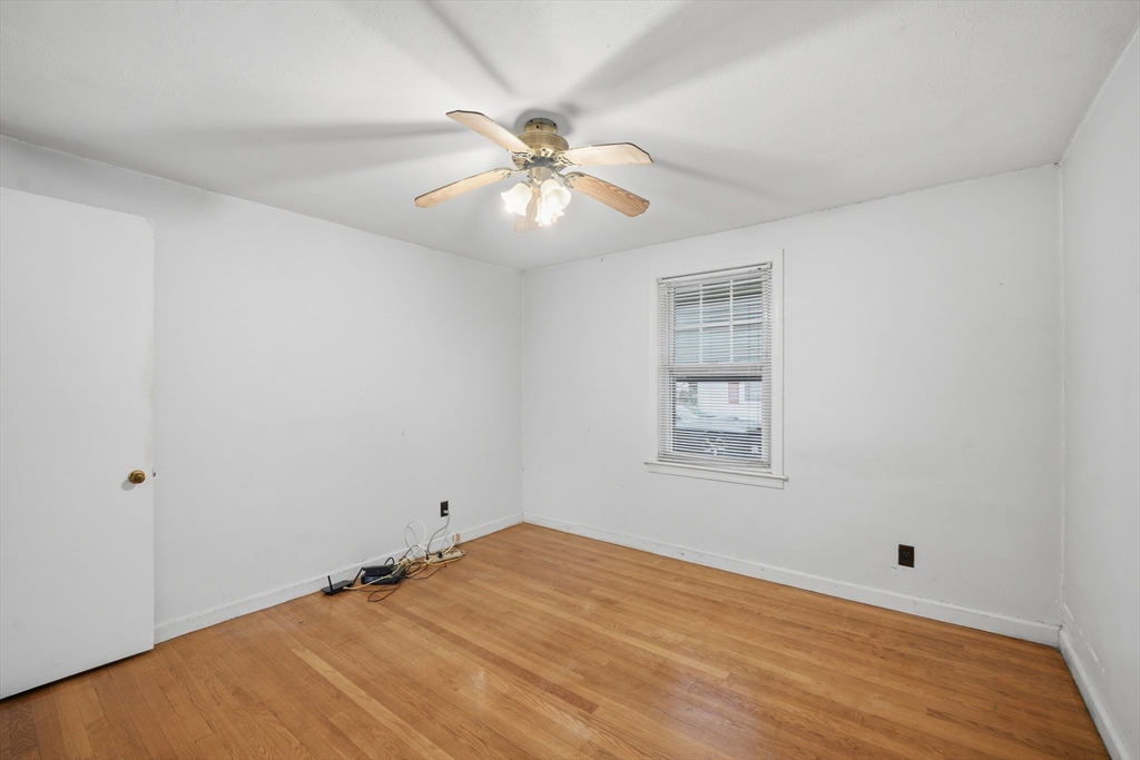 47 Holy Cross Street Springfield, MA 01104 - Photo 15 of 22 wooden floor in an empty room with a window