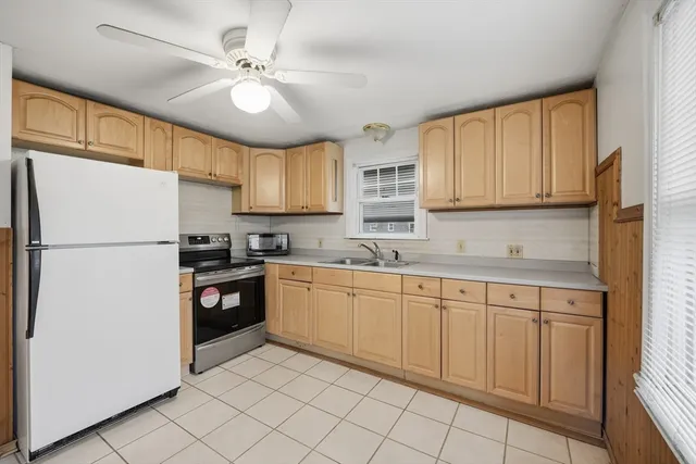 a kitchen with granite countertop white cabinets white appliances and sink