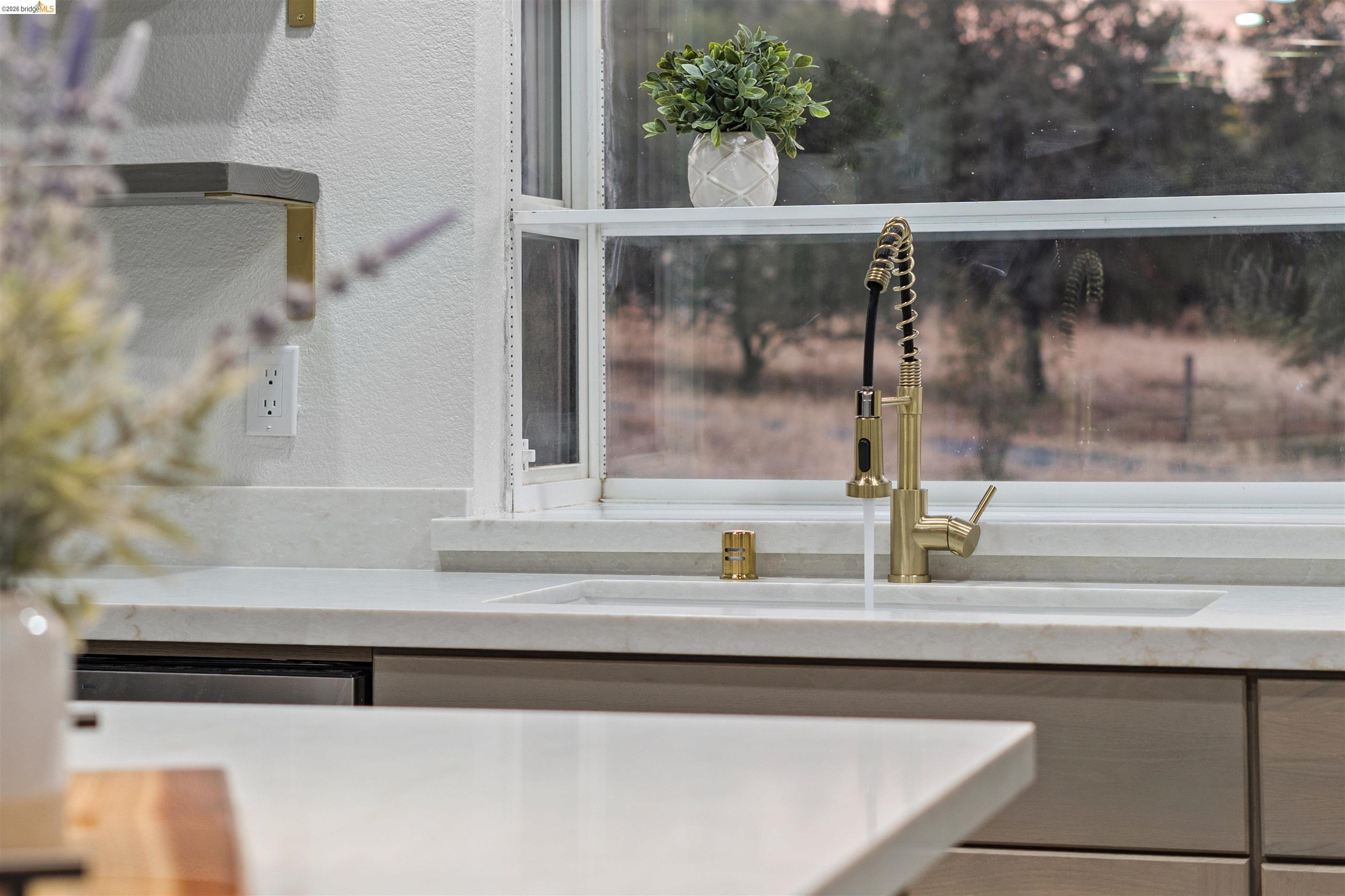 19676 Rawhide Road Sonora, CA 95370 - Photo 13 of 67 Integrated sink with a brass-finish pull-down faucet, light-toned countertop, and light wood-finish cabinetry