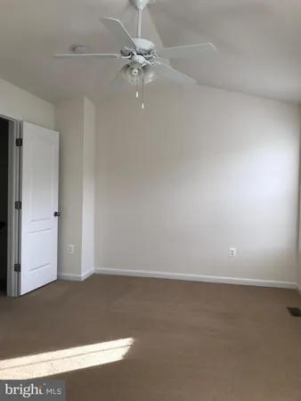 an empty room with a ceiling fan and window