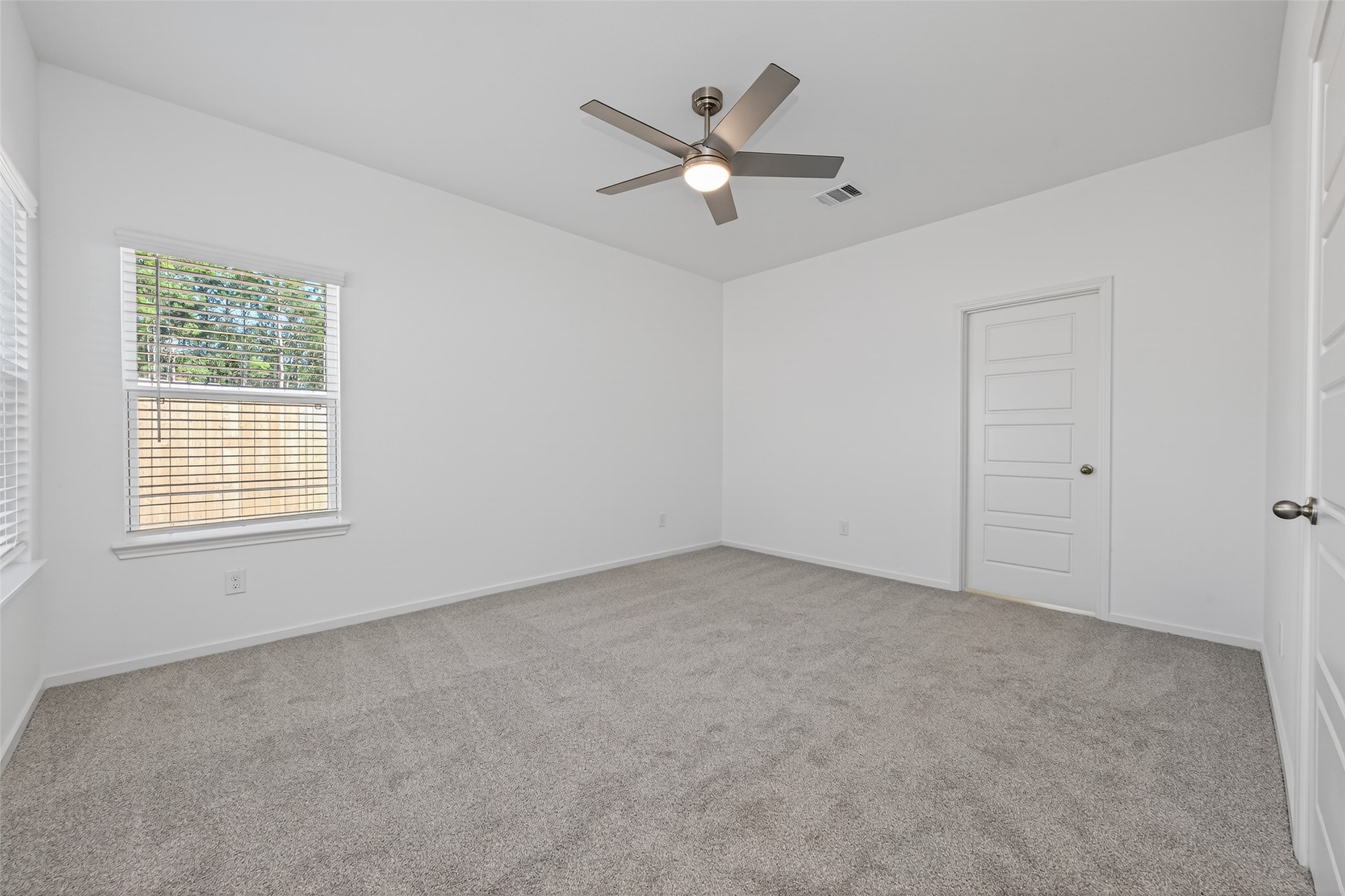 9718 Enclave Ridge Road Willis, TX 77318 - Photo 22 of 34 an empty room with a ceiling fan and windows