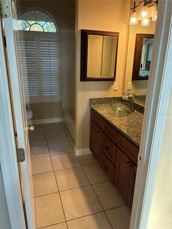 a bathroom with a granite countertop sink a mirror and a shower