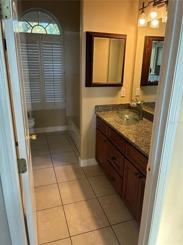 a bathroom with a granite countertop sink a mirror and a shower