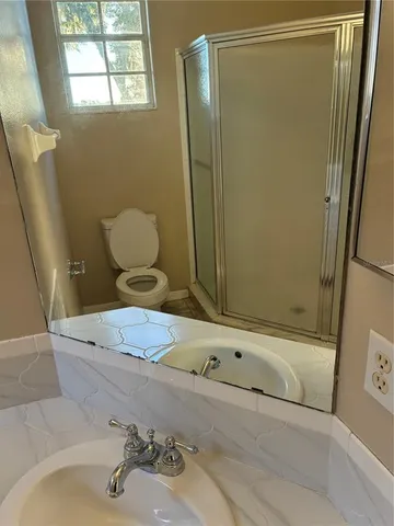 a bathroom with a sink a toilet and shower