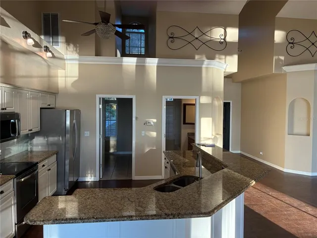 a kitchen with granite countertop a sink a stove and cabinets
