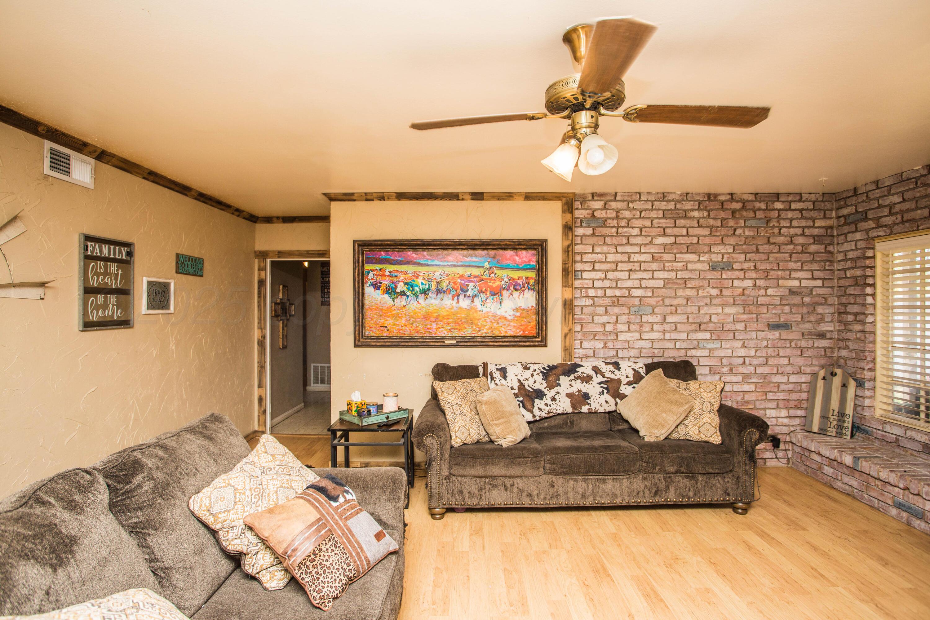 50 Fannin Drive Tulia, TX 79088 - Photo 11 of 40 a living room with furniture and a chandelier