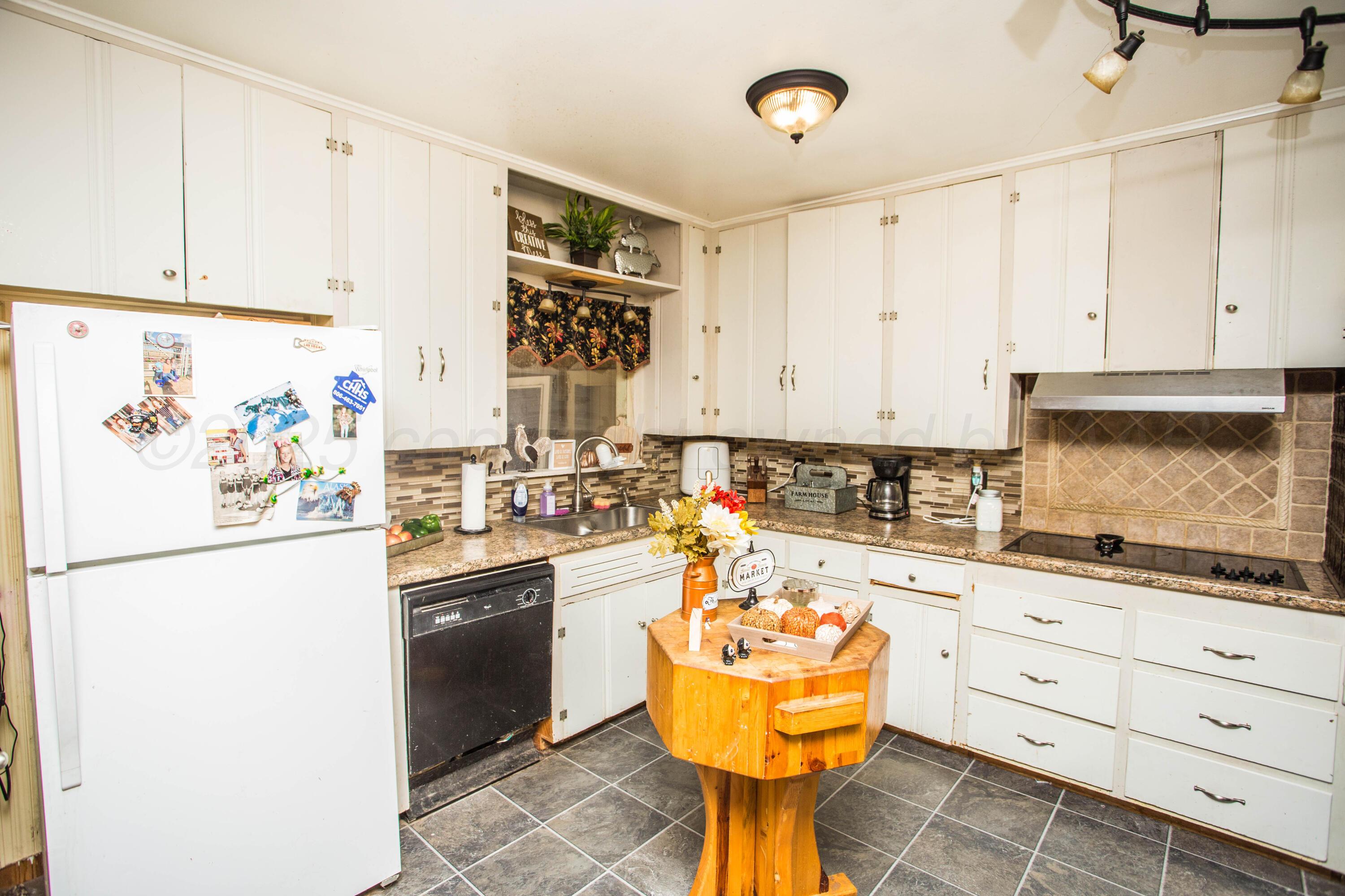 50 Fannin Drive Tulia, TX 79088 - Photo 16 of 40 a kitchen with granite countertop a sink a stove and refrigerator