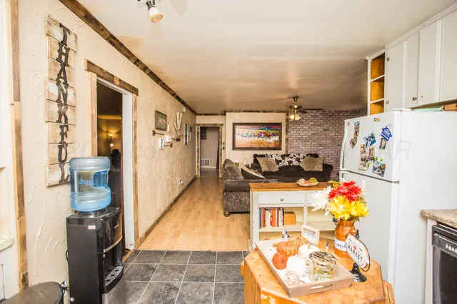 a living room with a couch and a dining table with wooden floor