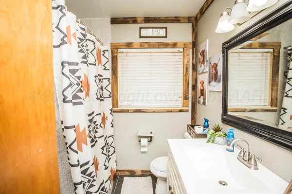 a bathroom with a sink a toilet and a window