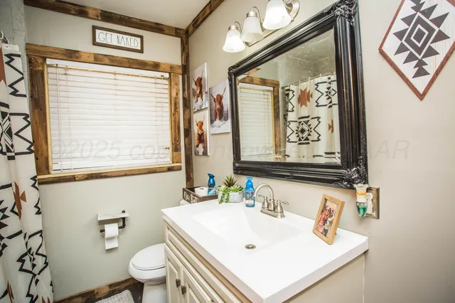 a bathroom with a sink mirror and a window