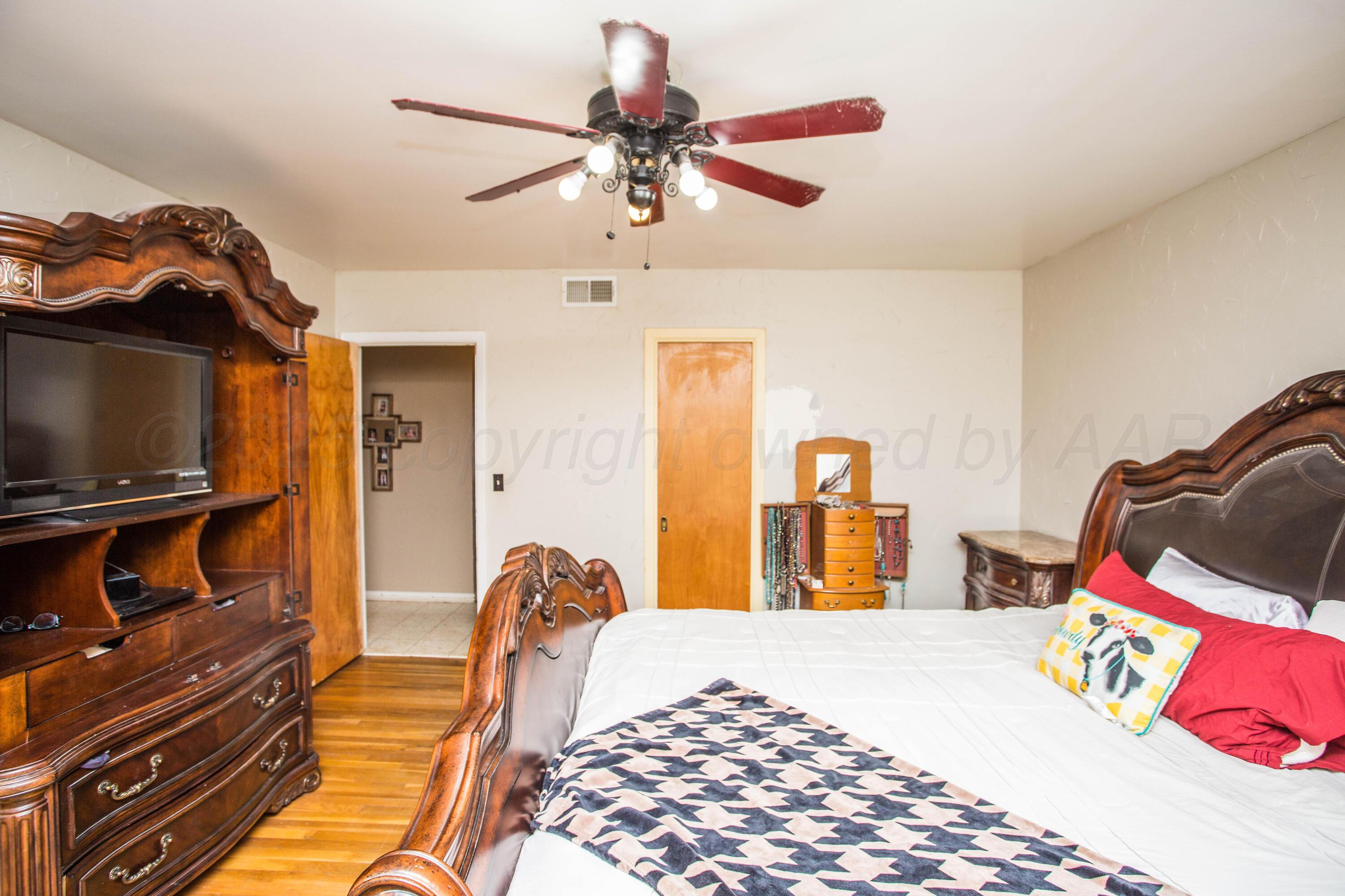 50 Fannin Drive Tulia, TX 79088 - Photo 36 of 40 a bedroom with a bed and a chandelier