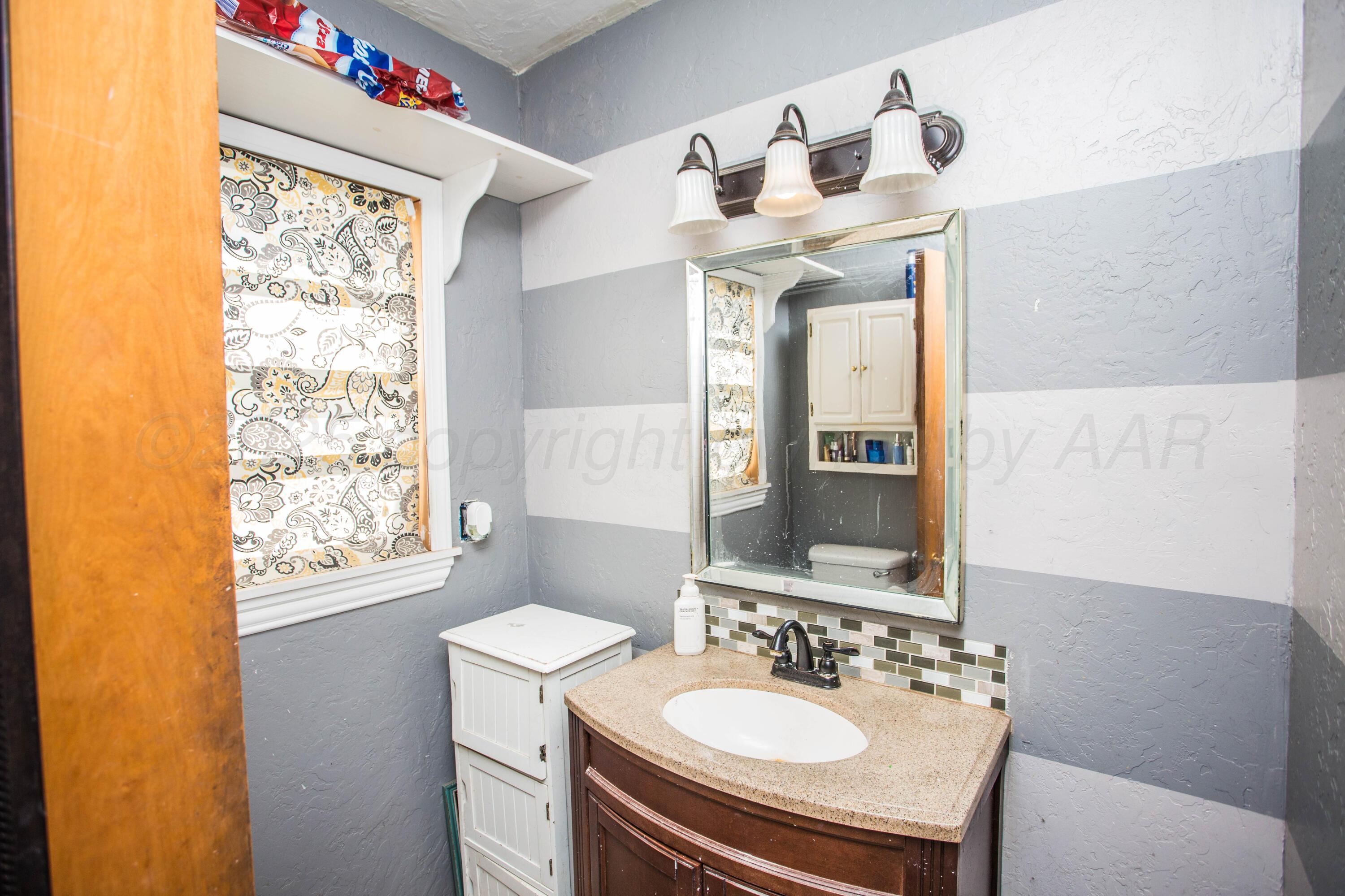 50 Fannin Drive Tulia, TX 79088 - Photo 38 of 40 a bathroom with a sink vanity mirror and a bathtub