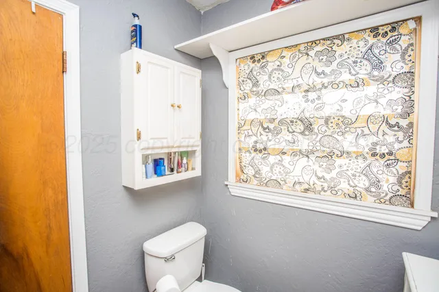 a white toilet sitting next to a window