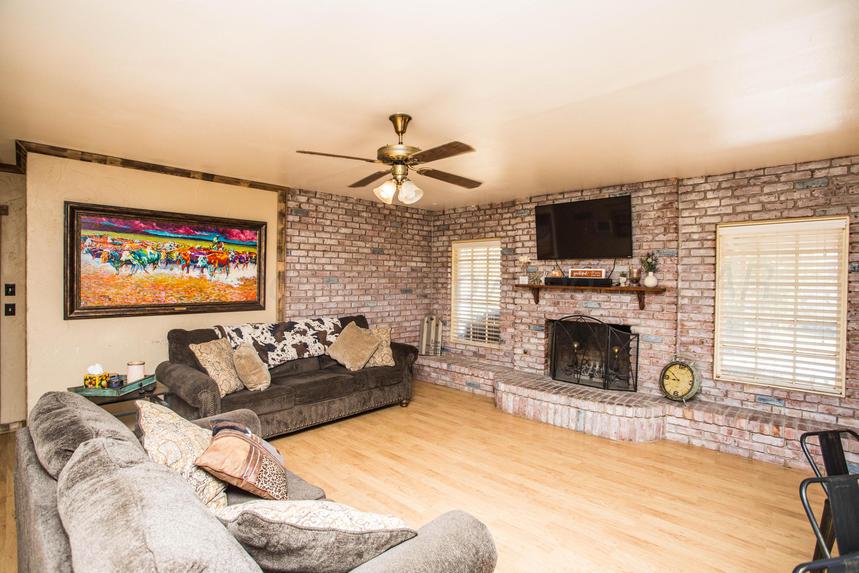 50 Fannin Drive Tulia, TX 79088 - Photo 9 of 40 a living room with furniture a fireplace and a flat screen tv