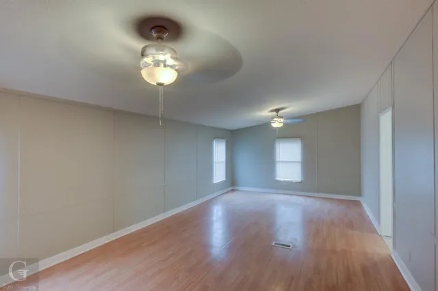 a view of an empty room with a chandelier fan