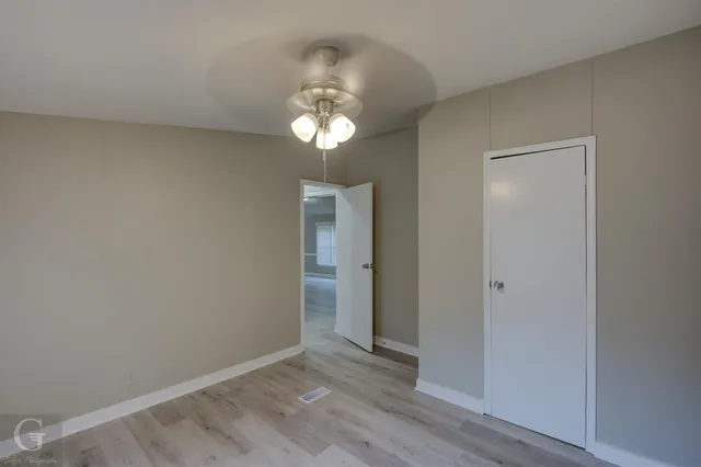 an empty room with wooden floor and window