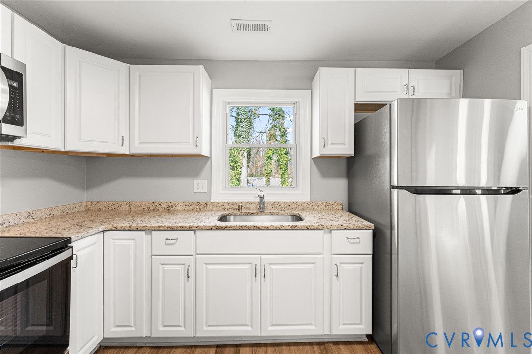 1847 Darbytown Road Henrico, VA 23231 - Photo 9 of 25 a kitchen with stainless steel appliances granite countertop a refrigerator sink and white cabinets