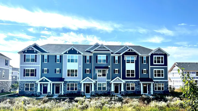 a kitchen with stainless steel appliances a refrigerator stove microwave and a dining table with wooden floor