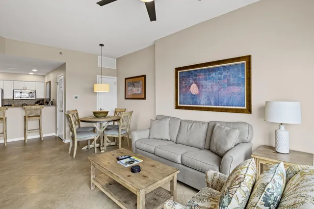 a living room with furniture and a dining table with kitchen view
