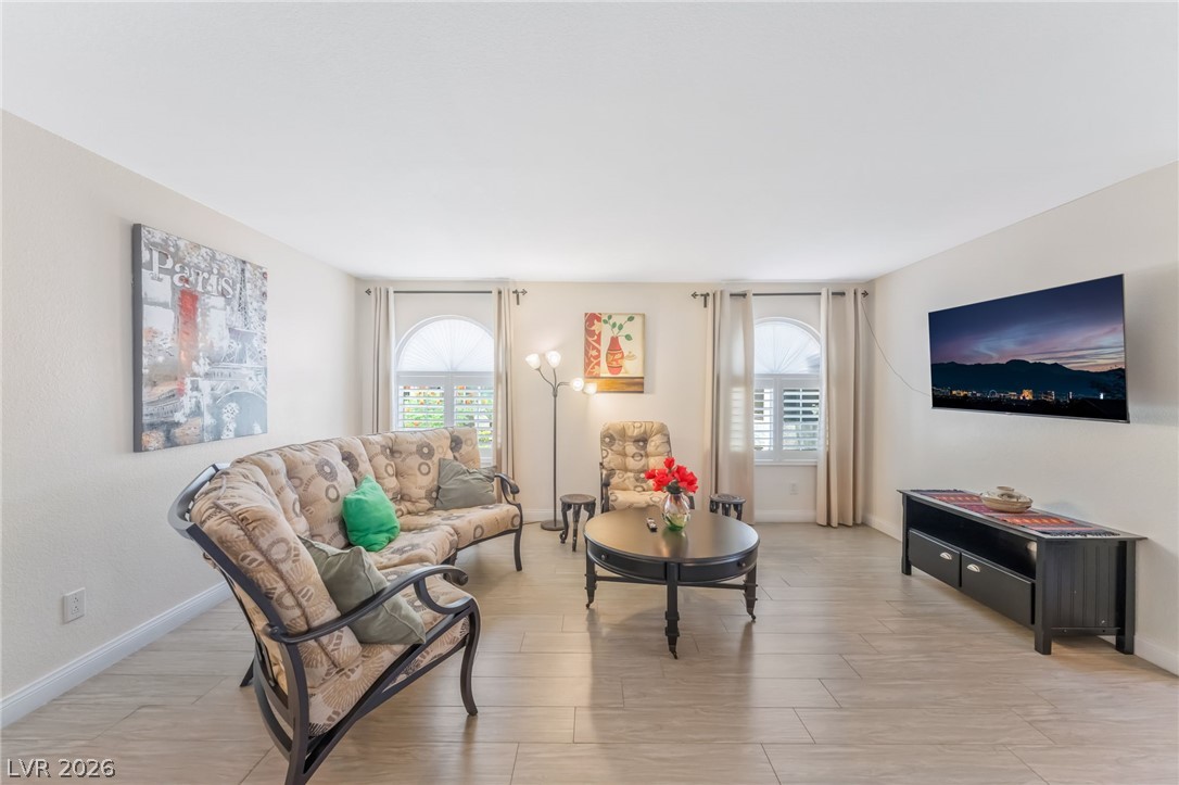 3145 East Flamingo Road, Unit 1092 Las Vegas, NV 89121 - Photo 3 of 33 Natural light floods this living area, showcasing its attractive flooring and window shutters.