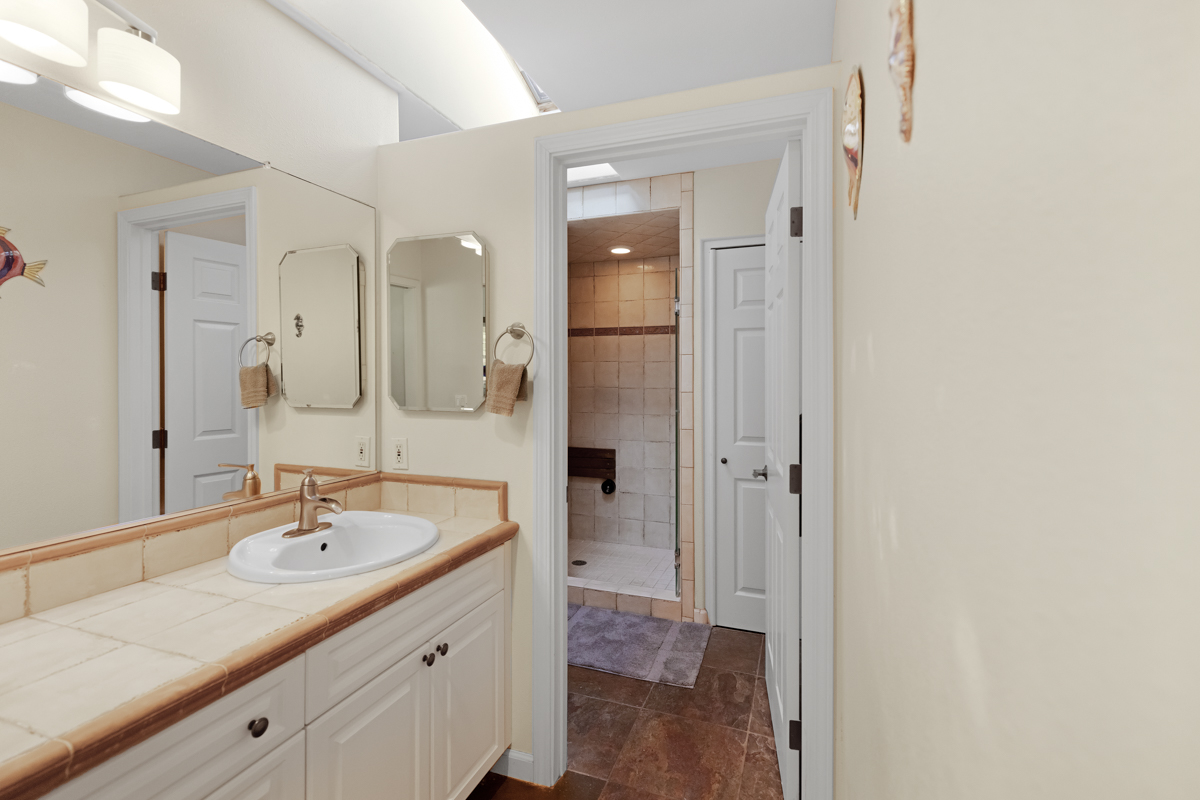 77-6596 Walua Road Kailua-Kona, HI 96740 - Photo 15 of 20 a spacious bathroom with a granite countertop sink and a mirror