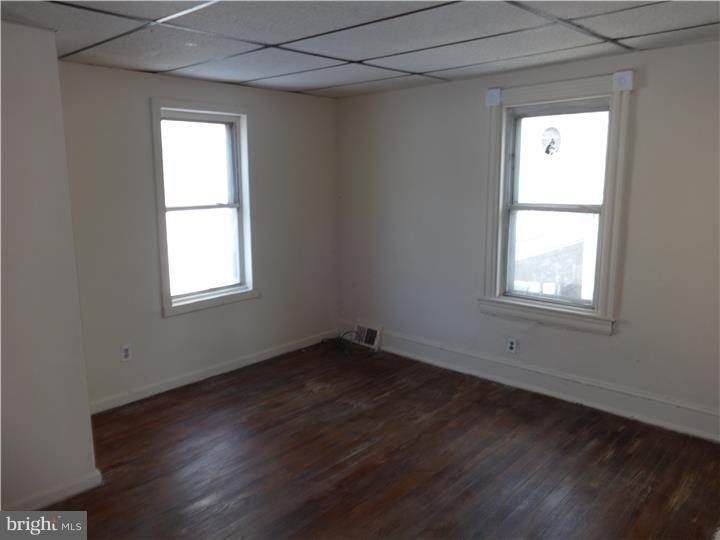 905 Wagontown Road Coatesville, PA 19320 - Photo 8 of 11 an empty room with wooden floor and windows