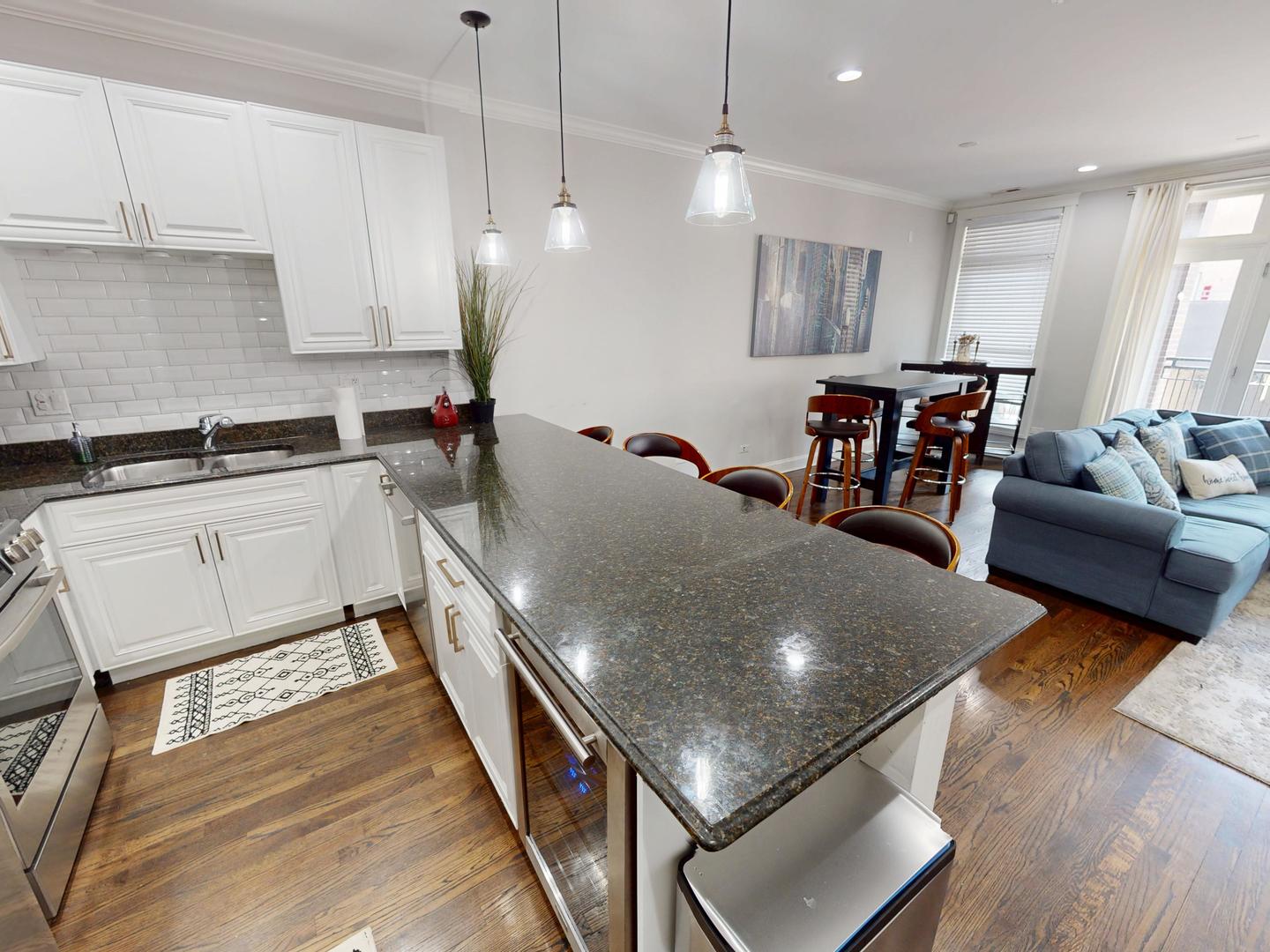 31 North Morgan Street, Unit 2 Chicago, IL 60607 - Photo 4 of 17 a kitchen with stainless steel appliances granite countertop a stove a sink a microwave a dining table and chairs