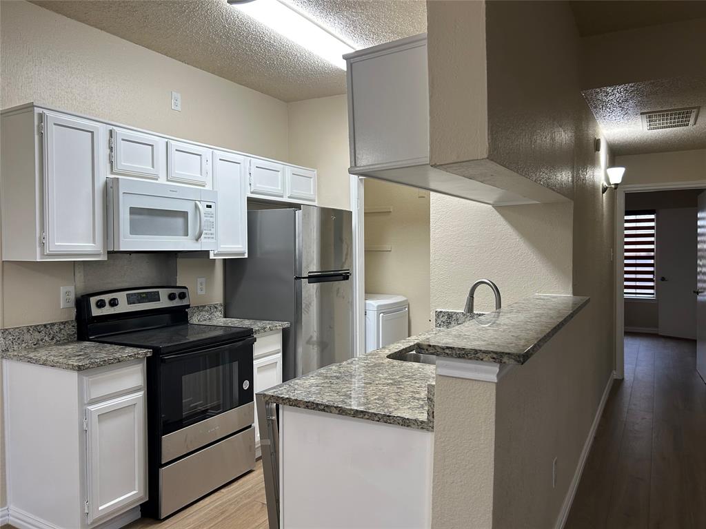 a kitchen with granite countertop a sink stove and refrigerator