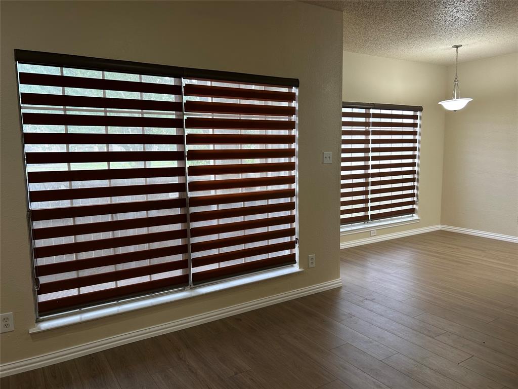 4101 Esters Road, Unit 103 Irving, TX 75038 - Photo 11 of 14 an empty room with wooden floor and windows