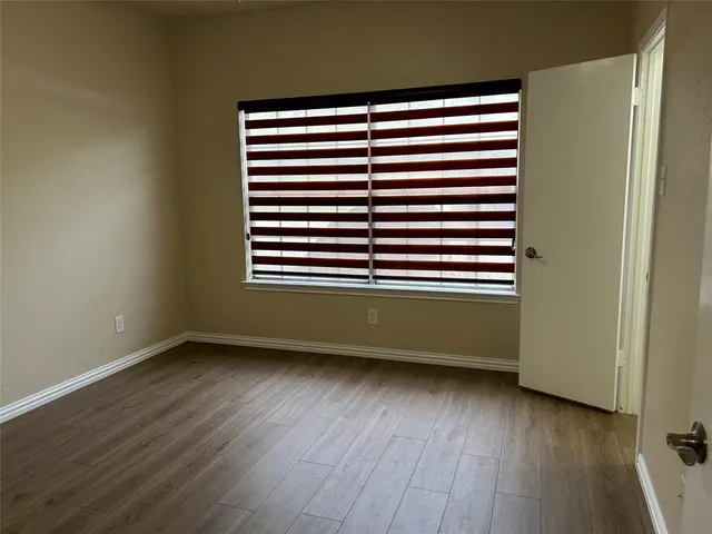 an empty room with wooden floor and a window
