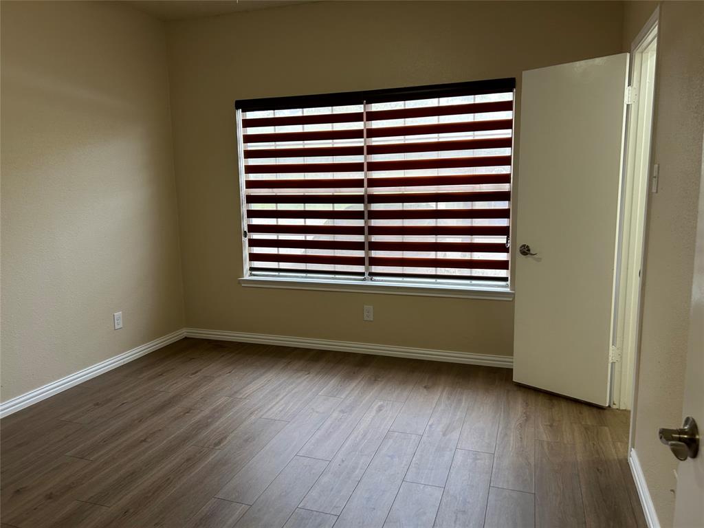 4101 Esters Road, Unit 103 Irving, TX 75038 - Photo 13 of 14 an empty room with wooden floor and a window