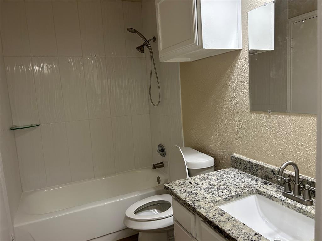 4101 Esters Road, Unit 103 Irving, TX 75038 - Photo 6 of 14 a bathroom with a granite countertop sink toilet and shower
