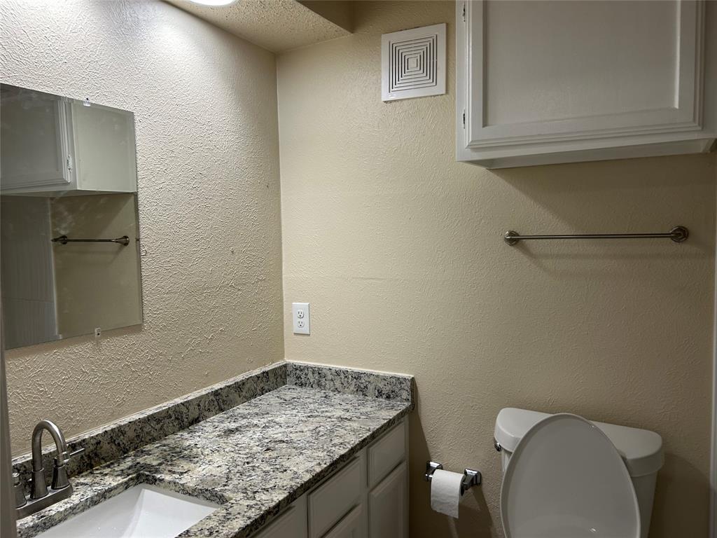 4101 Esters Road, Unit 103 Irving, TX 75038 - Photo 7 of 14 a bathroom with a granite countertop toilet and sink