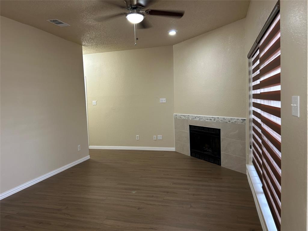 4101 Esters Road, Unit 103 Irving, TX 75038 - Photo 10 of 14 an empty room with wooden floor fireplace and windows